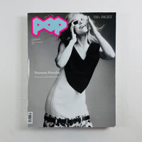 A single magazine lying flat on a light neutral background. The cover is predominantly black-and-white with a large bright pink and blue 'POP' masthead at the top left, plus visible text including 'Vanessa Paradis' and '700+ PAGES'.