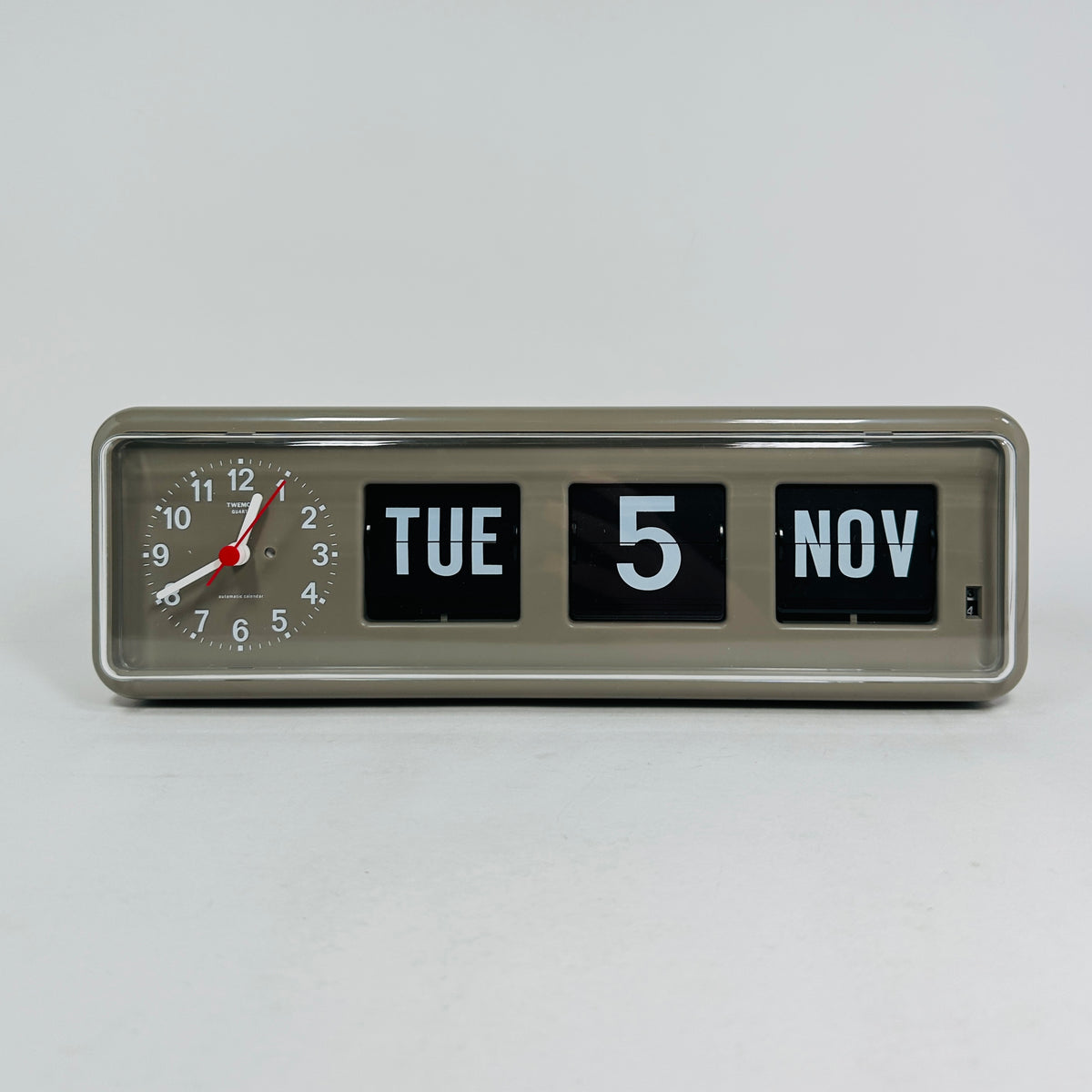 Retro grey analog flip clock with clock face and vintage mechanical flip date, mid-century modern desk or wall clock