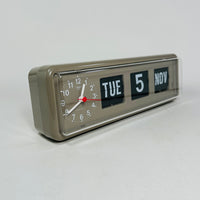 Retro grey analog flip clock with clock face and vintage mechanical flip date, mid-century modern desk or wall clock