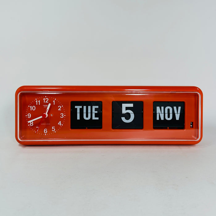 Retro orange analog clock with clock face and vintage mechanical flip date, mid-century modern desk or wall clock