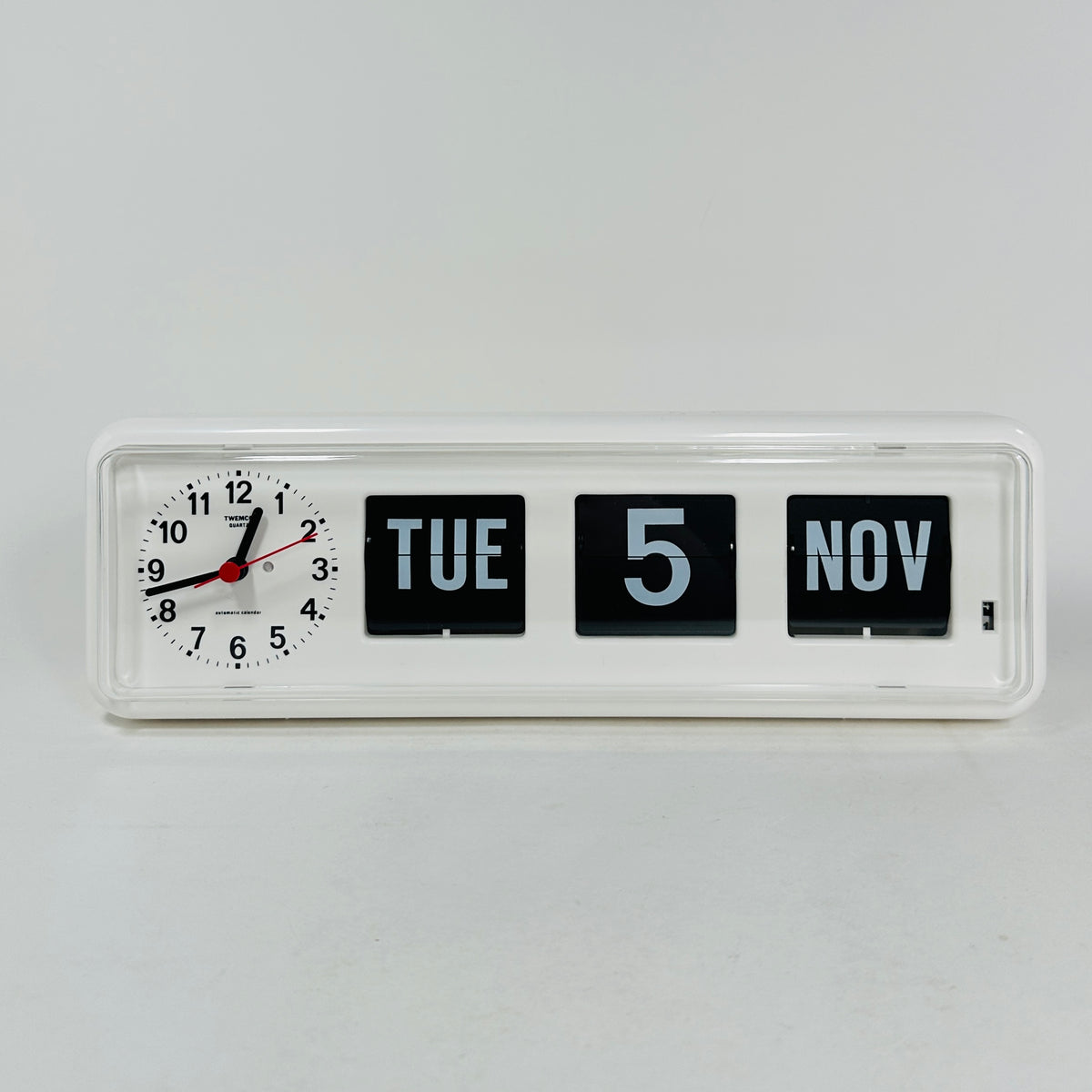 Retro white analog clock with clock face and vintage mechanical flip date, mid-century modern desk or wall clock